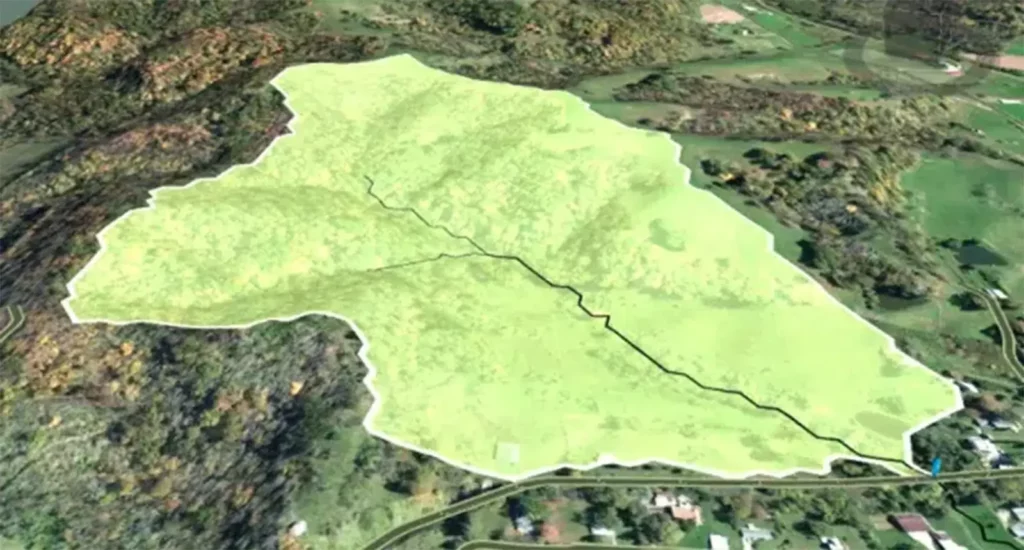 GeoSTORM automated catchment delineation showing a color-highlighted watershed boundary and drainage network over aerial terrain imagery, illustrating automatic identification of catchments and subbasins from elevation data for accurate runoff modeling.